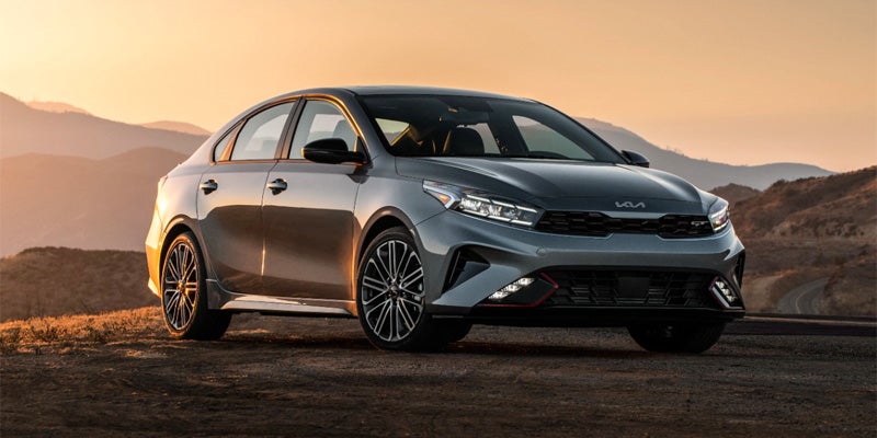 grey 2024 kia forte parked on a dirt road during sunset