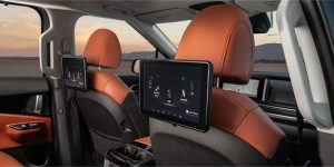 interior of 2024 Kia Carnival showing back of pilot and passenger seats with media screens attached to the headrests